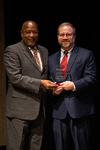 Dr. Jeff Johnson, ISU Alumni Association President, presents the ISU Outstanding Young Alumni Award to Dr. Loy