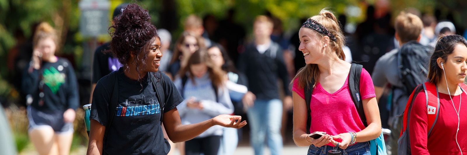 Students on campus walking and talking with each other.