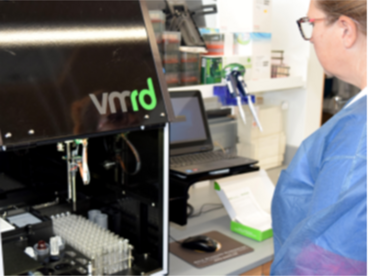 An NVDC laboratory technician works at an automated ELISA processor.