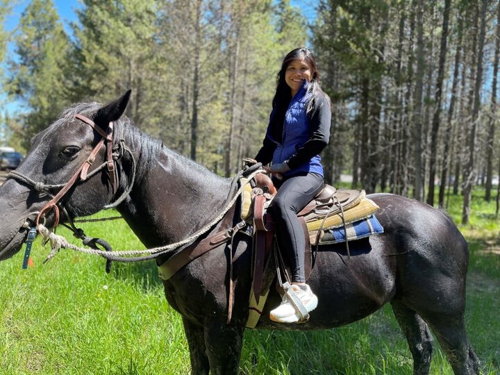 Duan Loy sitting in saddle atop a horse.