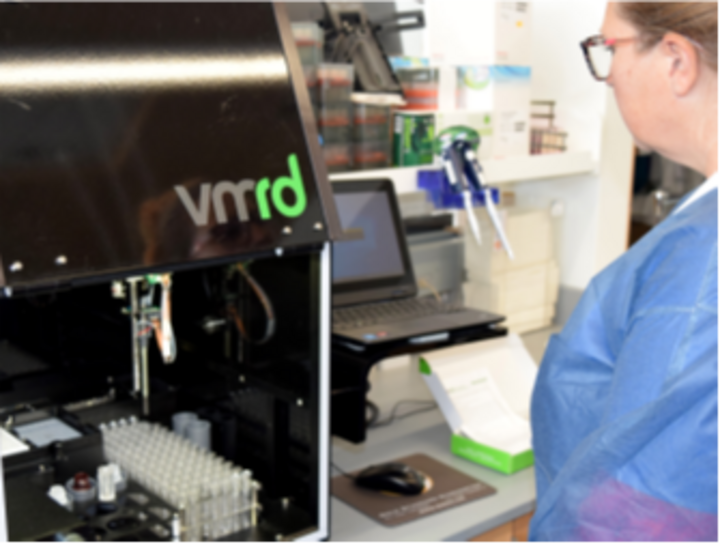 A female technician uses an automated ELISA processor.